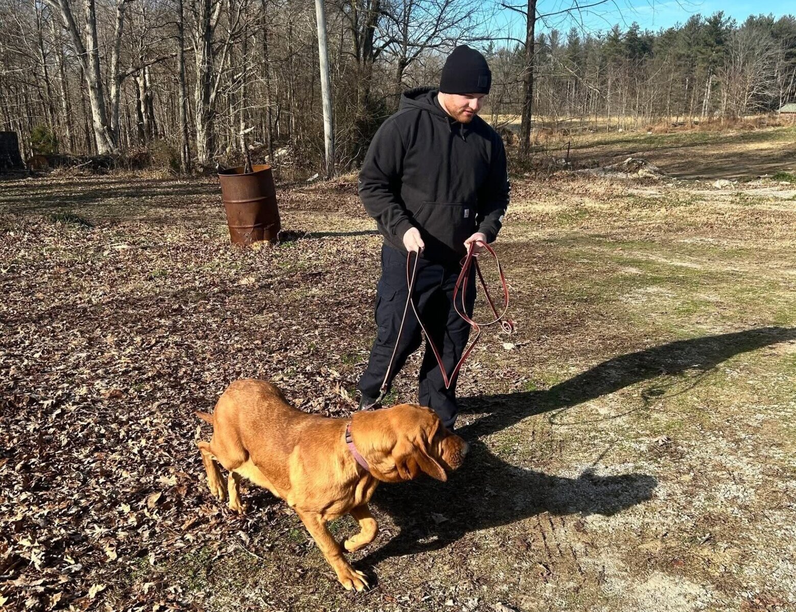 bloodhound with handler dressed in all black and black beanie