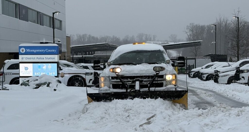 A plow clears a parking lot in Gaithersburg, Maryland, on Sunday, Jan. 25, 2026. (WTOP/Steve Dresner)