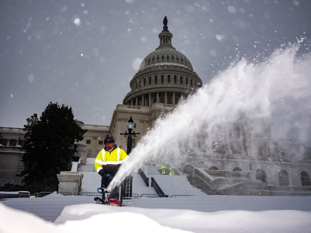 WASHINGTON, DC - JANUARY 25: An Architect of the Capitol worker clears snow from the West front of the U.S. Capitol on January, 25, 2026 in Washington, DC. A massive winter storm is bringing frigid temperatures, ice, and snow to nearly 200 million Americans from Texas to New England. (Photo by Kent Nishimura/Getty Images)