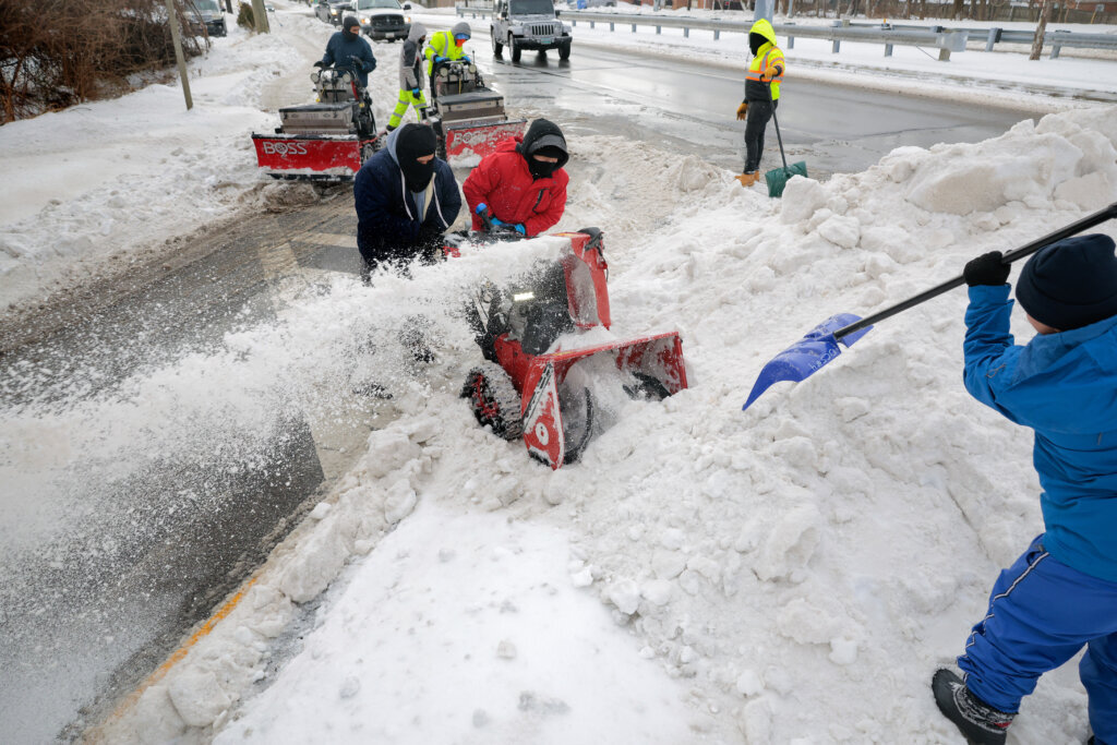 A crew uses a snowblower and small excavators to clear sidewalks at the intersection of Interstate 495 and University Boulevard East following a winter storm on January 26, 2026 in Silver Spring, Maryland. A massive winter storm is expected to bring frigid temperatures, ice, and snow to millions of Americans across the nation. (Photo by Chip Somodevilla/Getty Images)