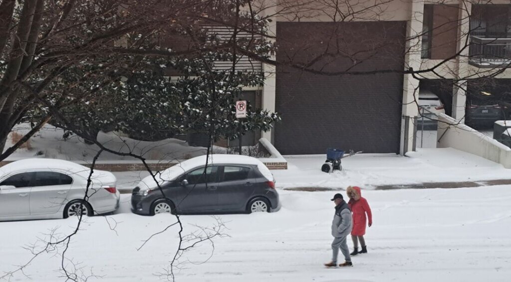 A couple walks in the snow in Arlington, Virginia, on Sunday, Jan. 25, 2026. (WTOP/Sandy Kozel)