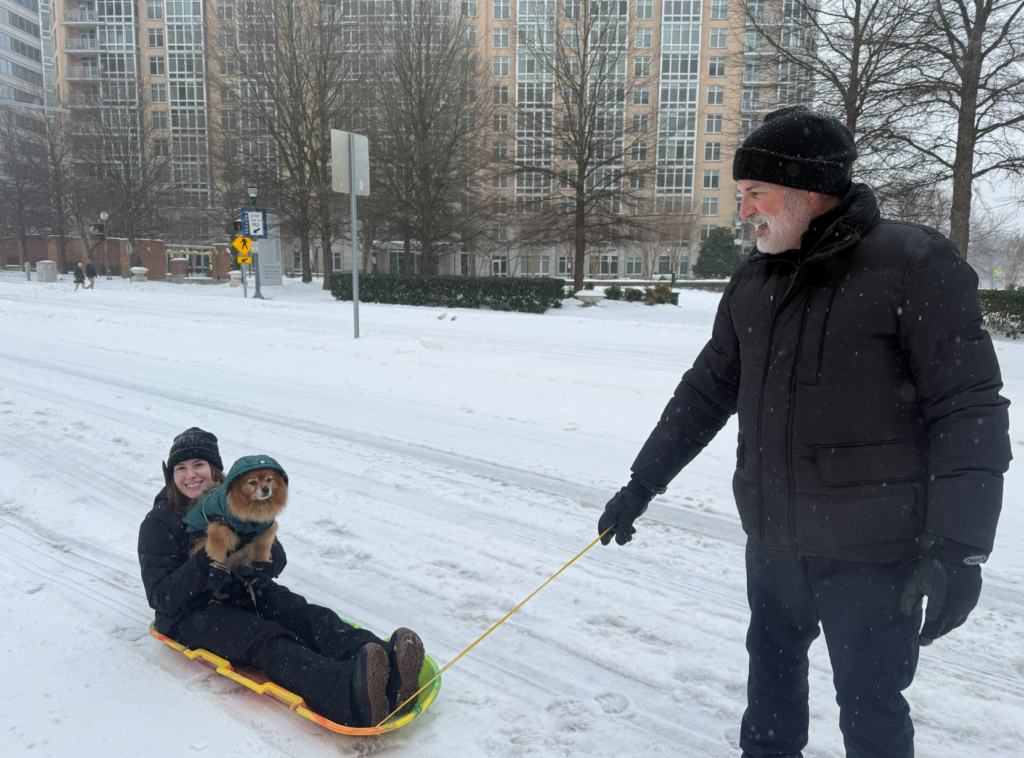 Members of the Mirala family take their dog during a snowy walk in Montgomery County, Maryland.