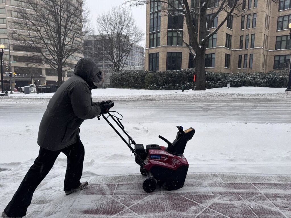 A worker clears a sidewalk in Friendship Heights, Maryland, on Sunday, Jan. 25, 2026. (WTOP/Giang Nguyen)