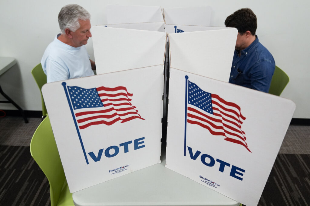 Two people mark ballots at a Falls Church polling place