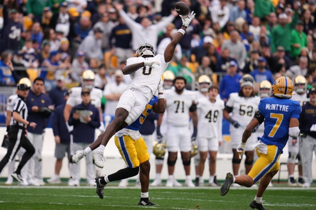 Notre Dame wide receiver Malachi Fields (0) hauls in a pass from quarterback CJ Carr as Pittsburgh defensive back Rashad Battle (15) defending during the first half of an NCAA college football game in Pittsburgh, Saturday, Nov. 15, 2025. (AP Photo/Gene J. Puskar)