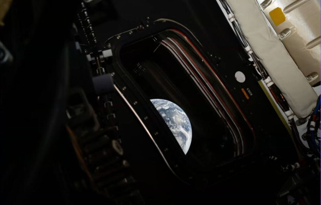 The Earth peeks through a window of the Orion capsule in this photo taken by NASA's Artemis II astronaut commander Reid Wiseman on Friday, April 3, 2026. (NASA via AP)