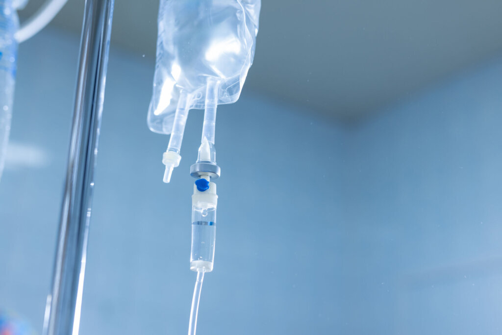 Close up of IV infusion system with clear fluid bag in a hospital setting