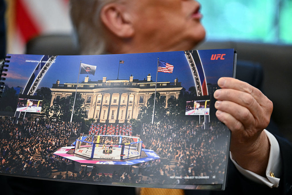U.S. President Donald Trump shows a rendering of the upcoming "UFC Freedom 250" event as he speaks in the Oval Office of the White House on May 6, 2026, in Washington, D.C. An Ultimate Fighting Championship event will be staged on the White House's South Lawn in June. (Photo by Kent NISHIMURA / AFP via Getty Images)